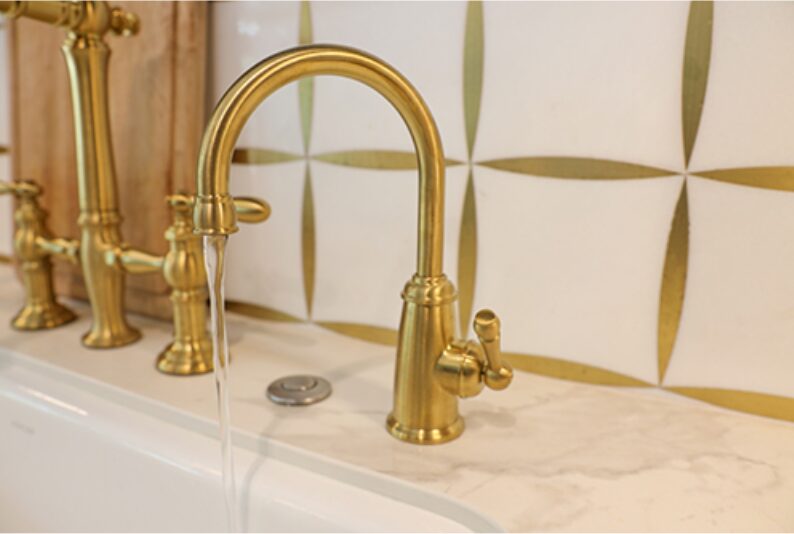 Polished brass faucet and handles on a bathroom sink