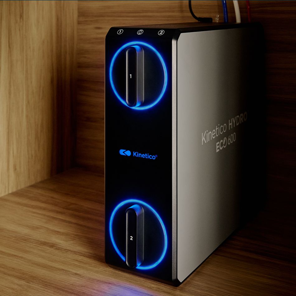A Kinetico HYDRO ECO system glowing under a kitchen sink