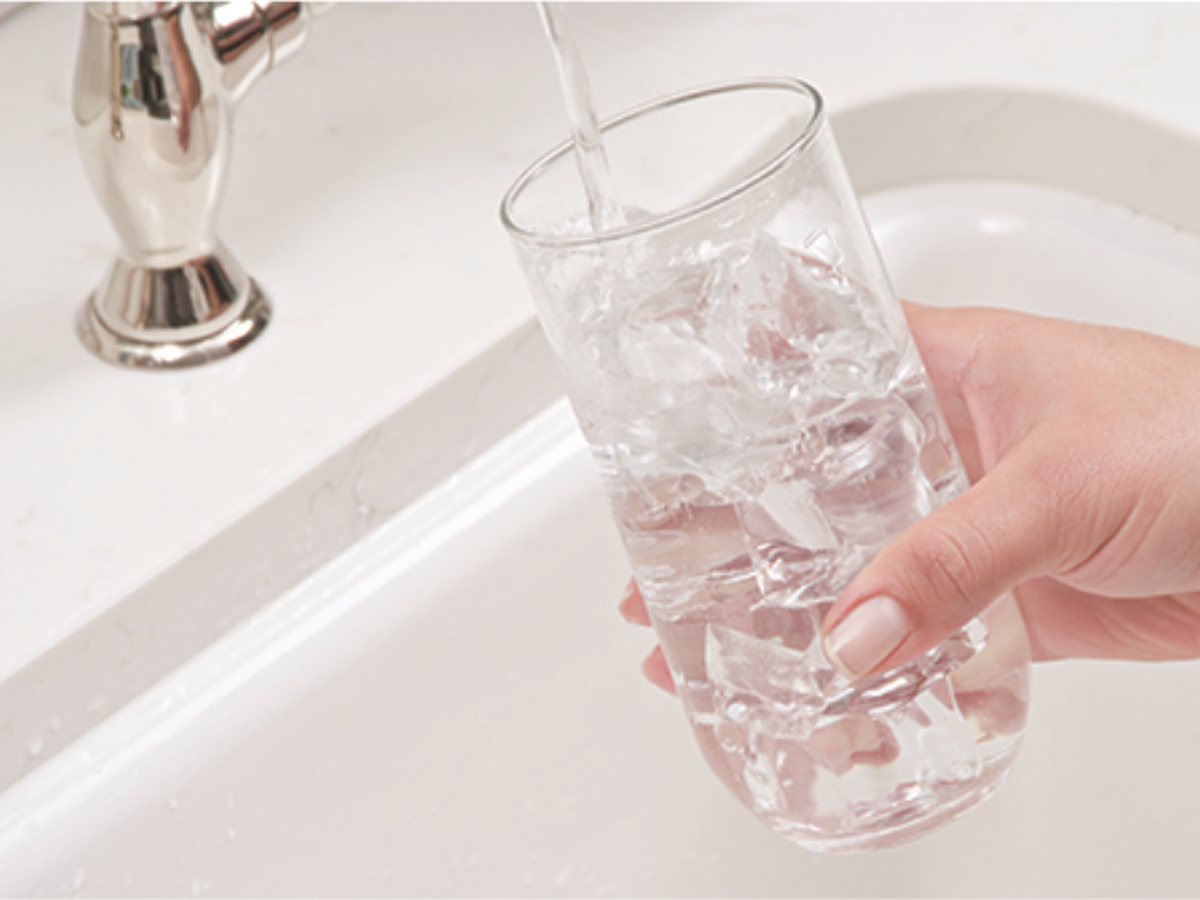 Filling a glass with filtered water at the kitchen sink