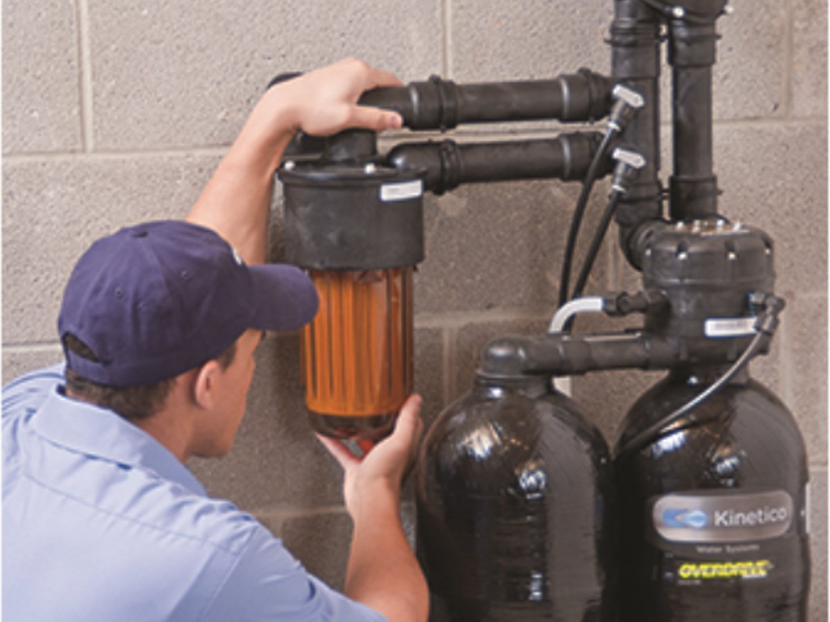 A technician servicing a Kinetico water softener