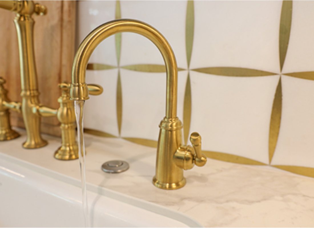 A brass drinking water faucet on a marble counter