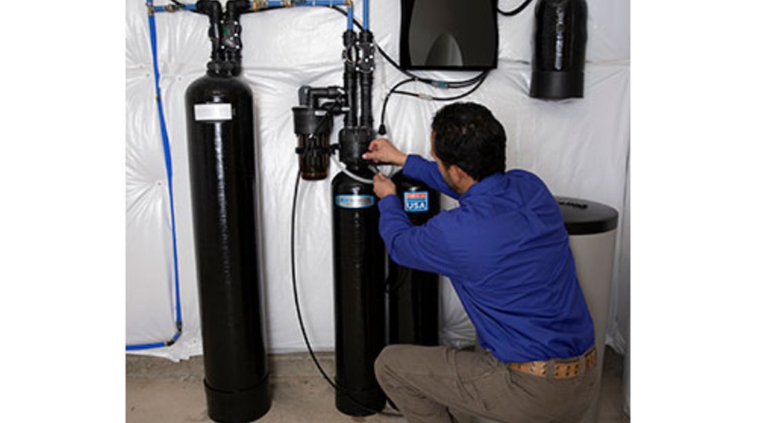 A Cardinal technician installing a Kinetico twin tank softener