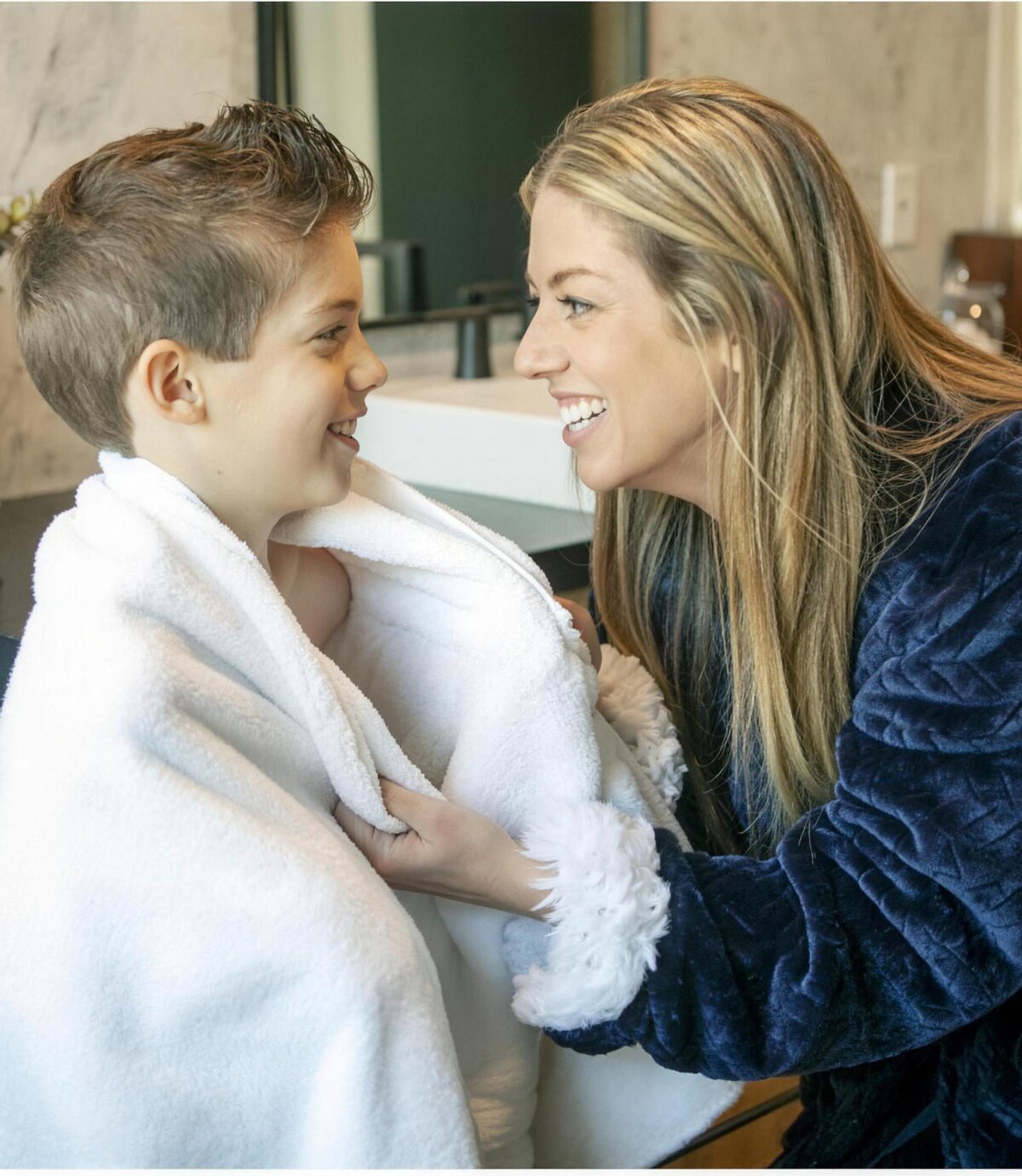 Mom wrapping her son in a warm towel after a bath