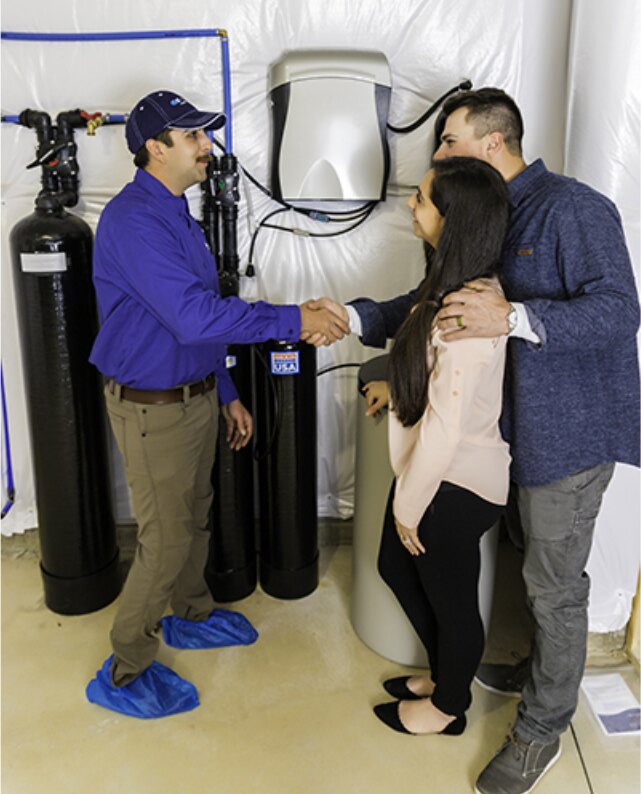 Kinetico technician shaking hands with homeowners