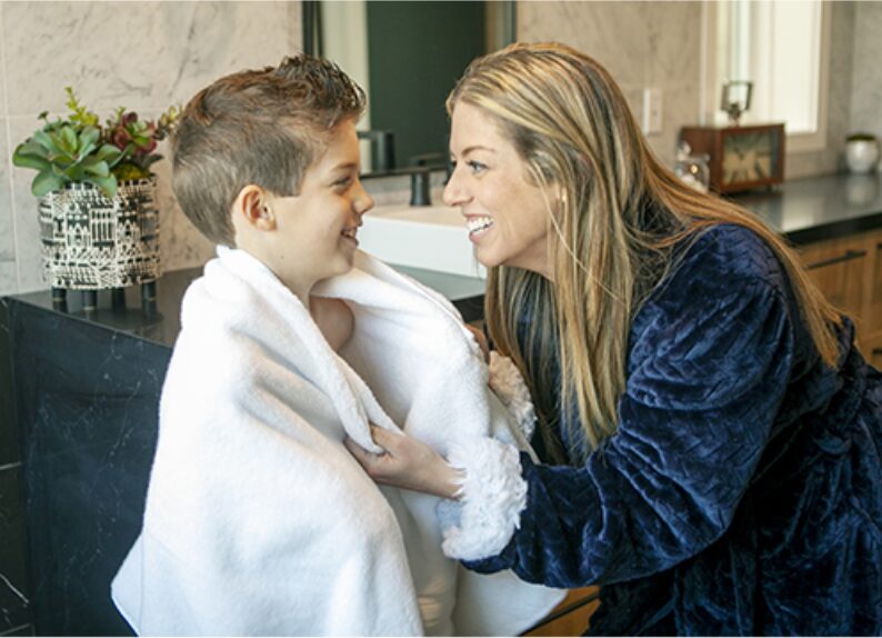 Mom wrapping her son in a warm towel after his bath