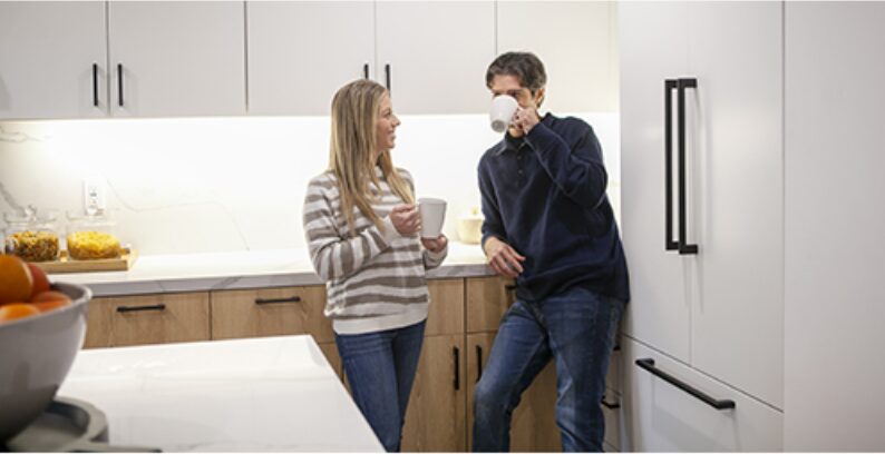 Couple talking over morning coffee in a bright kitchen