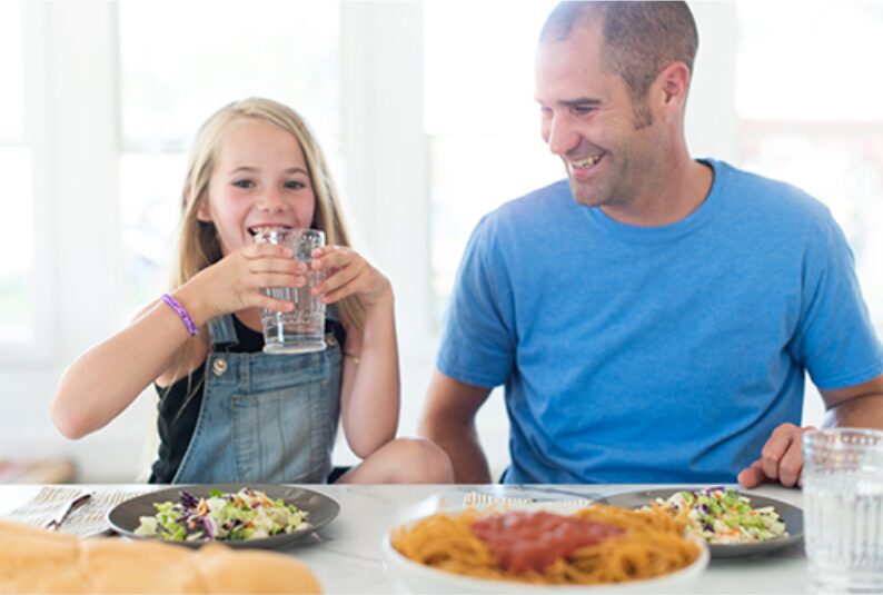 Father and daughter enjoying dinner together at the table